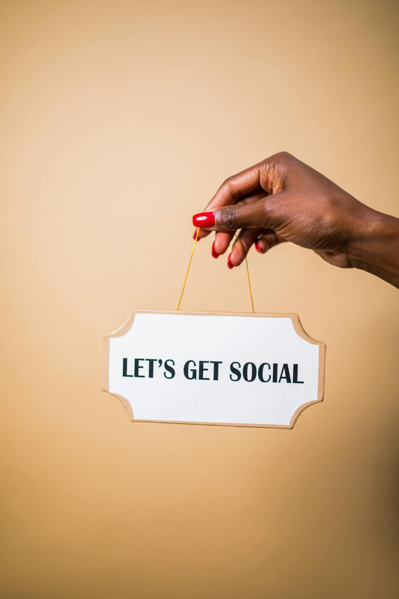 Media e Strumenti di marketing digitale 4 A hand holding a "Let's Get Social" sign, ideal for marketing and social media themes.